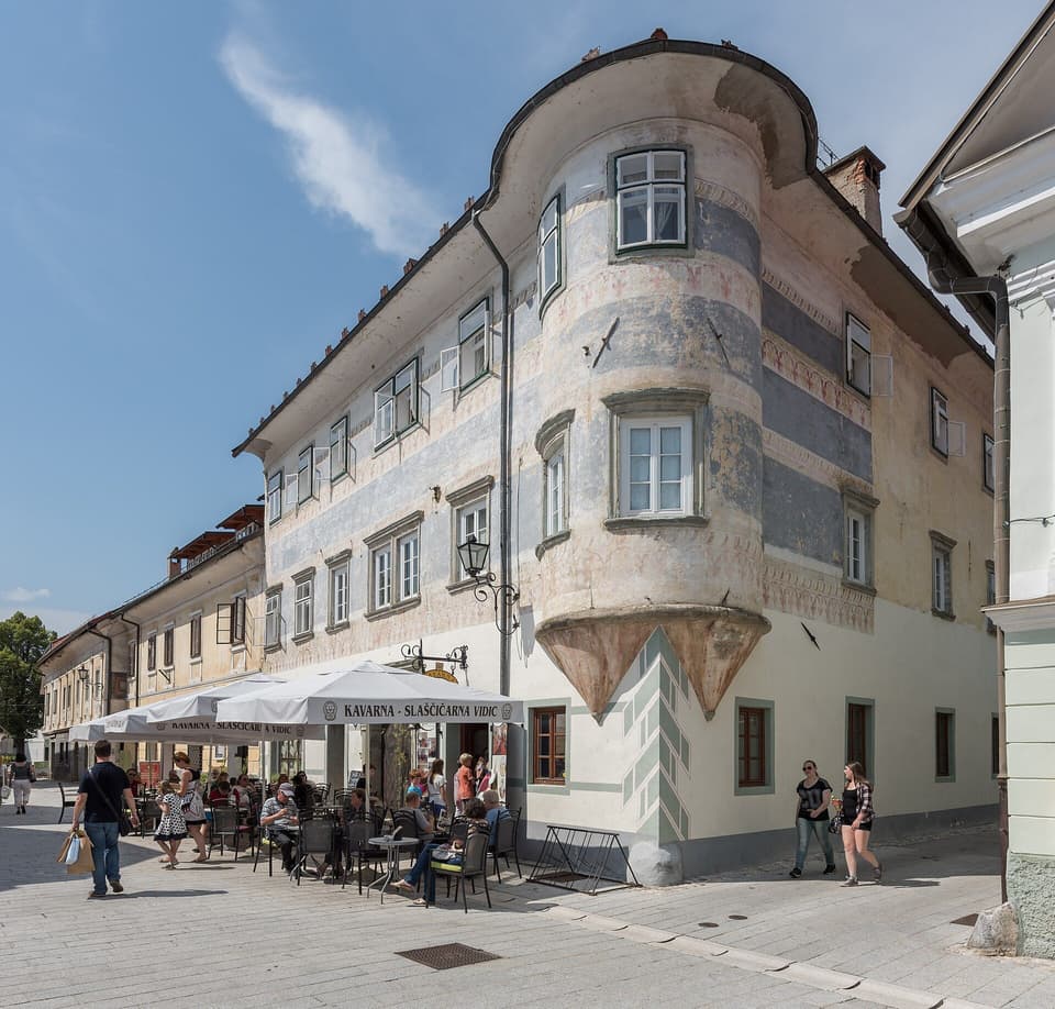 A cafÃ© terrace with white parasols on a quiet old-town square (illustrative)