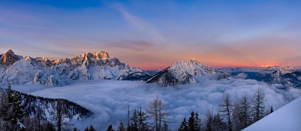 Mountain peaks catching first light above a sea of clouds (illustrative)
