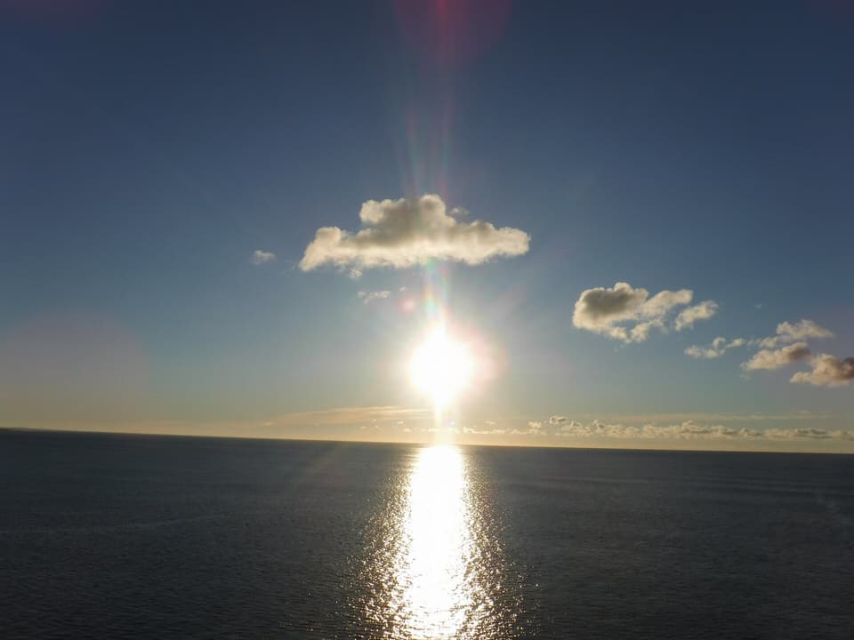 The sun rising over a calm open sea (illustrative)