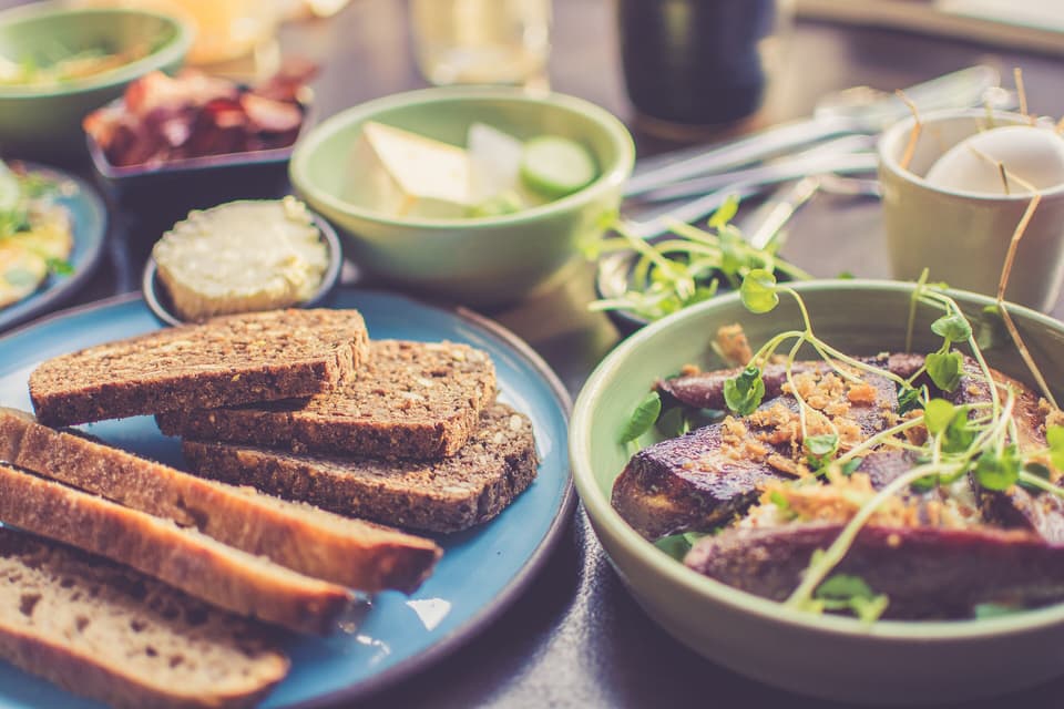 A shared table of bread, salads and dishes, seen from above (illustrative)