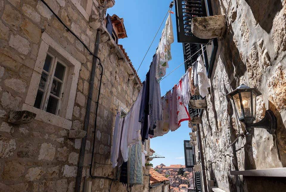 A narrow stone street in an old town, with a washing line overhead (illustrative)